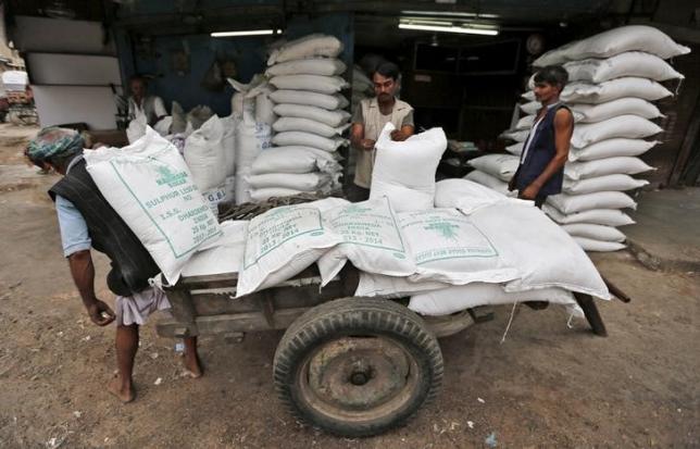 Workers unload sacks containing sugar from a handcart at a wholesale market in Ahmedabad, India, August 5, 2015. REUTERS/Amit Dave/Files